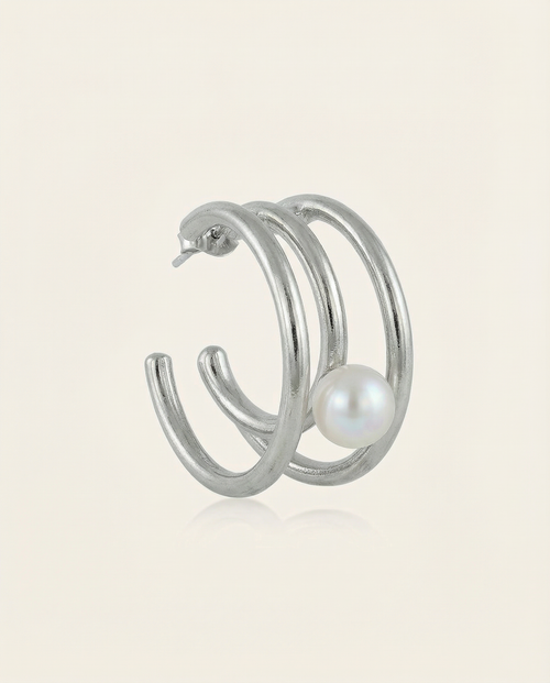 Silver hoop earring with a pearl on a light beige background
