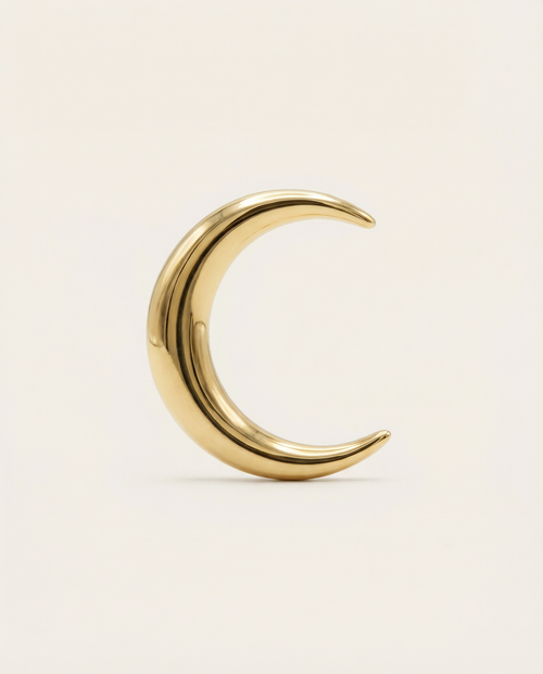 Gold crescent moon-shaped earring on a beige background