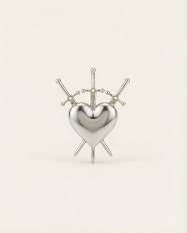 Silver heart-shaped ring with 3 swords design on a beige background